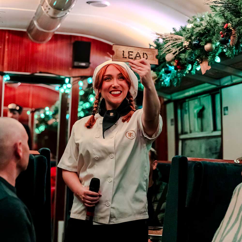 The conductor clipping tickets on THE POLAR EXPRESS™ Train Ride London